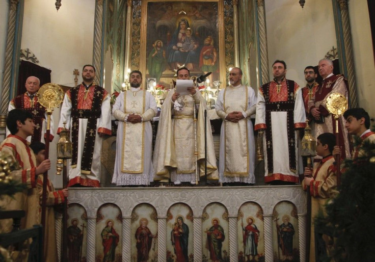 Christian clerics pray during a mass to celebrate the Orthodox Christmas at Saint Serkis church in Damascus