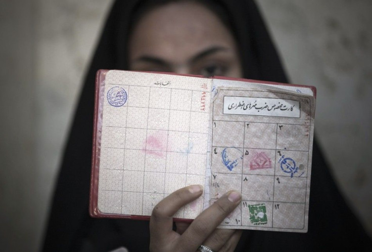A woman holds her identification in front of her face as she rests after voting at a polling station during Iran&#039;s parliamentary election in southern Tehran March 2, 2012.