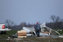 A resident works to clear storm damage after three tornadoes moved through the area in Chelsea, Indiana