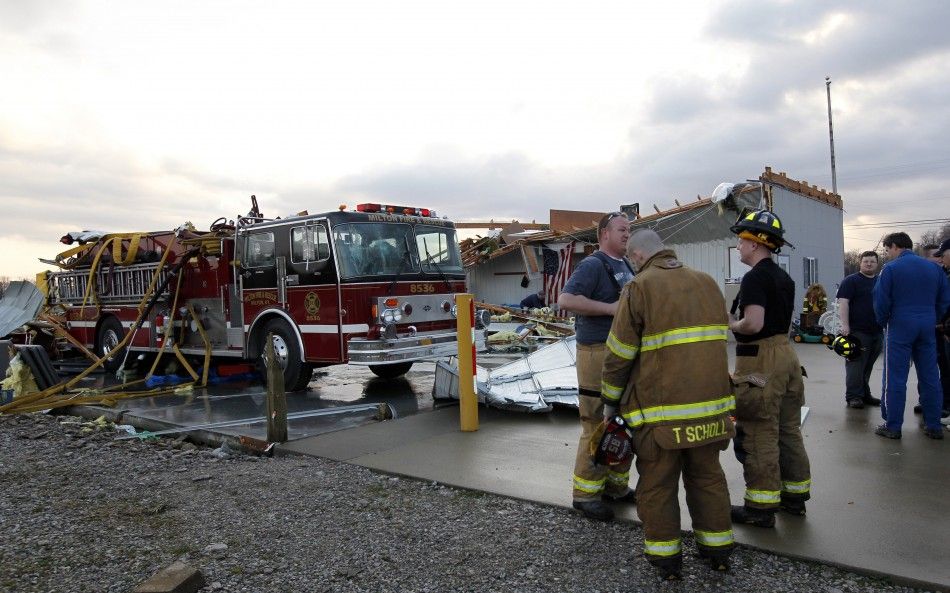 Members of the Milton Fire department work to clear storm damage after a tornado hit the fire house in Milton