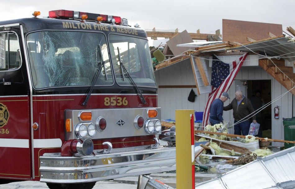 Members of the Milton Fire department work to clear storm damage after a tornado hit the fire house in Milton
