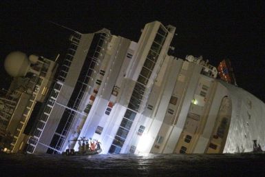 Rescuers are seen next Costa Concordia cruise ship that ran aground off the west coast of Italy at Giglio island January 14, 2012.