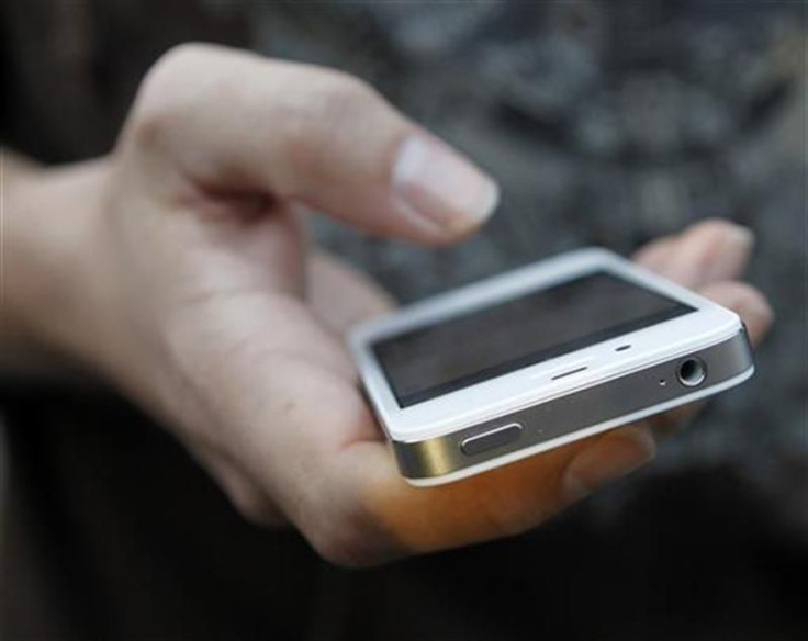 A customer uses his new iPhone 4S after making the purchase at Apple&#039;s flagship retail store in San Francisco