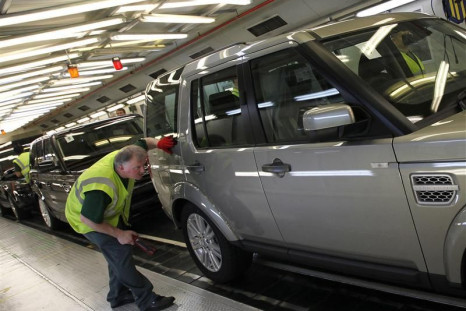 A worker inspects a Land Rover Discovery on the production line at their Production Facility in Solihull