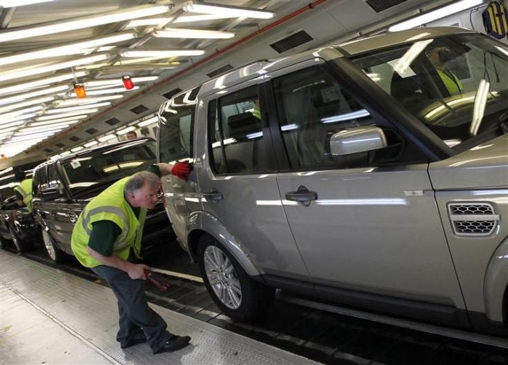 A worker inspects a Land Rover Discovery on the production line at their Production Facility in Solihull