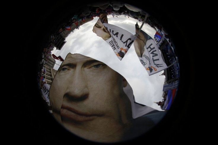 Supporters of Vladimir Putin wave flags in a picture taken with a fisheye lens before a rally in central Moscow.