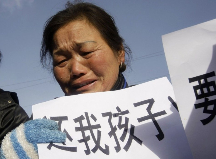 A woman, whose child died from drinking tainted milk, holds a sign outside Shijiazhuang Intermediate People's Court