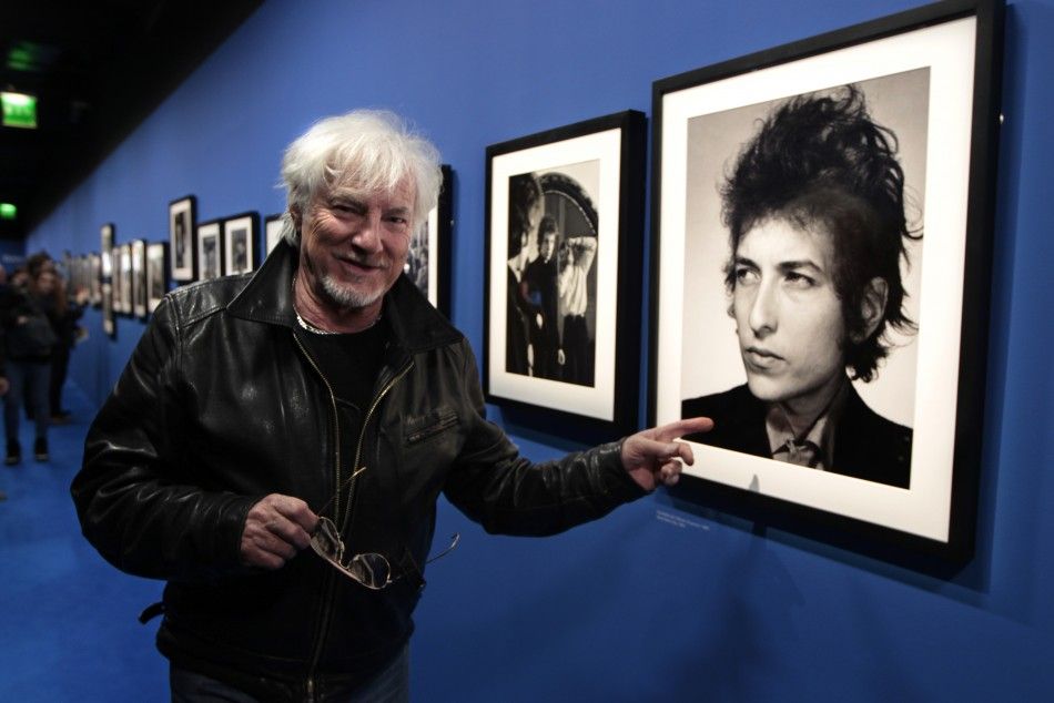 French singer Hugues Aufray points at a photograph of Dylan at the museum of the Cite de la Musique in Paris