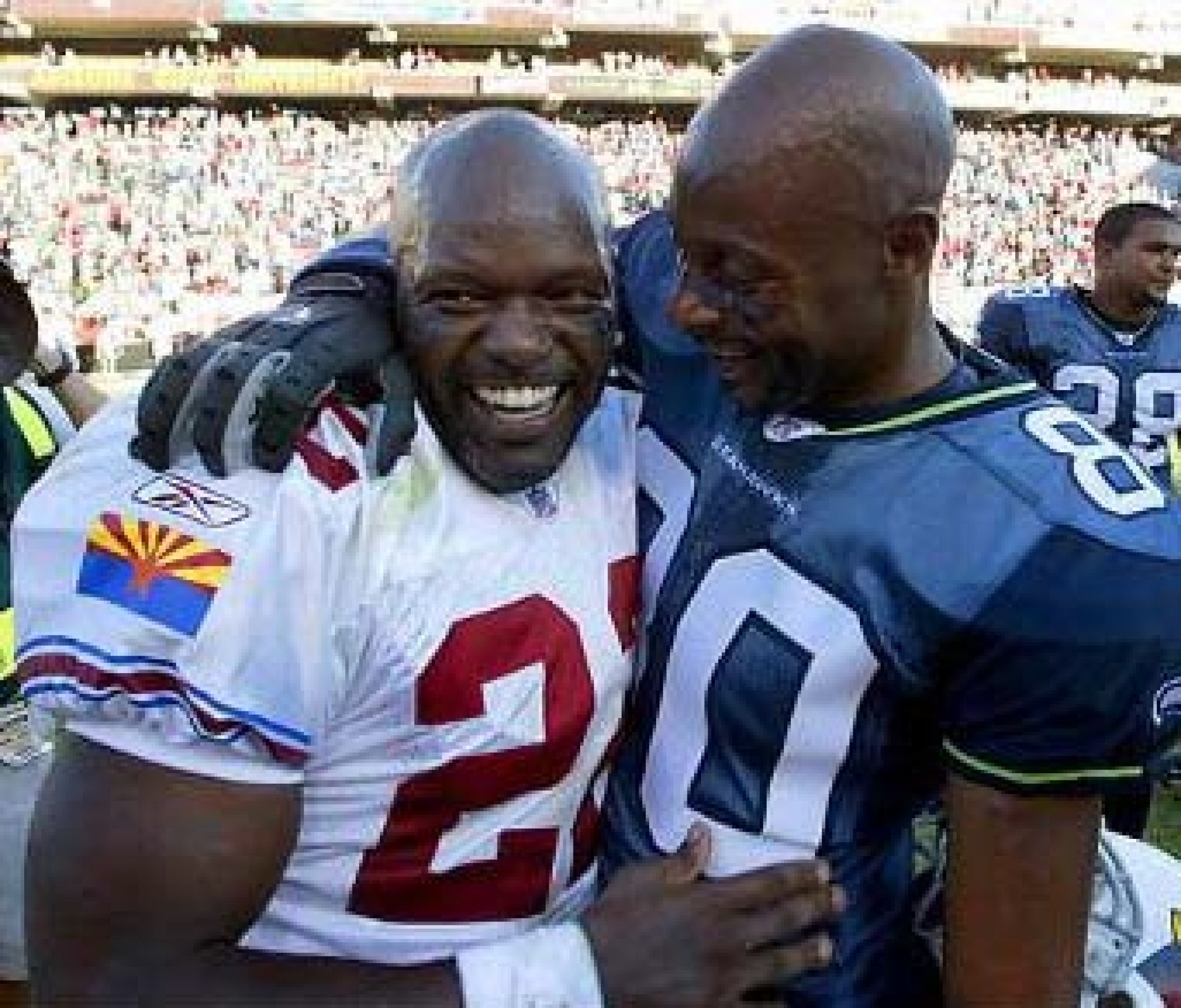 This photo just isnt right. The NFLs all-time leading rusher Emmet Smith and all-time leading reciever Jerry Rice embrace in foreign colors.