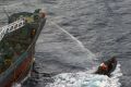 Handout picture of water canon being sprayed from Japanese whaling ship towards small Sea Shepherd boat off the coast of Antarctica.