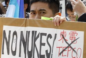 An anti-nuclear protester holds a placard during a rally in front of the headquarters of Tokyo Electric Power Co. (TEPCO), operator of the tsunami-crippled Fukushima Daiichi nuclear power plant, in Tokyo March 11, 2012, to mark the first anniversary of th