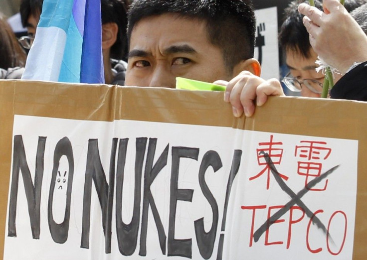 An anti-nuclear protester holds a placard during a rally in front of the headquarters of Tokyo Electric Power Co. (TEPCO), operator of the tsunami-crippled Fukushima Daiichi nuclear power plant, in Tokyo March 11, 2012, to mark the first anniversary of th