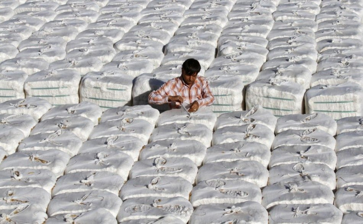 A trader checks stacked boxes of cotton inside a cotton processing unit at Kadi