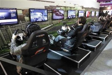 Visitors play a car racing video game during a visit at the Paris Games Week show in Paris October 21, 2011. The Paris Games Week will run from October 21 to October 25.