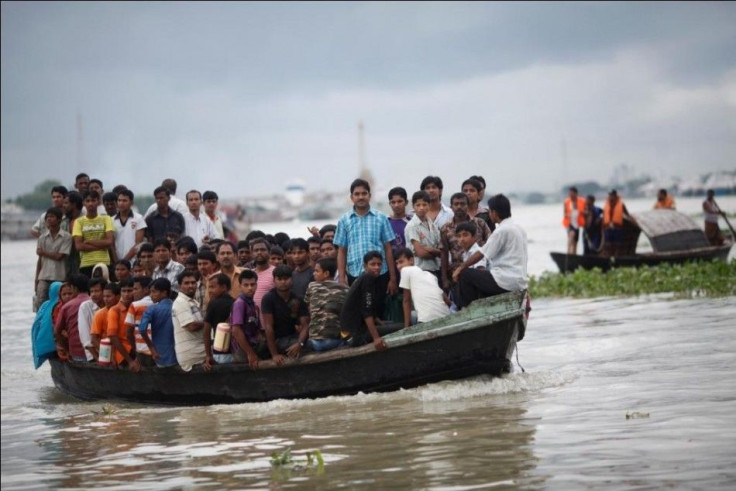 An overcrowded ferry crosses the River Shitalakkhya, while a rescue team is seen on right after another ferry was struck by a sand barge and capsized in Narayanganj.