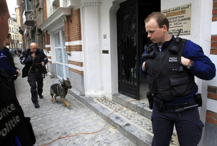 A police officer with a sniffing dog arrives at the Rida mosque which has been set on fire in Anderlecht commune in the west of Brussels