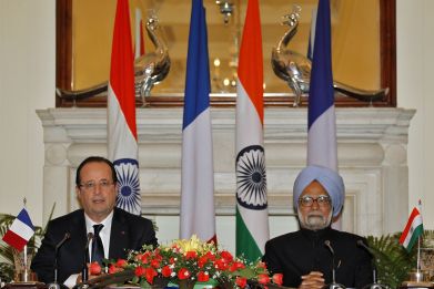 France's President Francois Hollande (L) speaks with the media as India's Prime Minister Manmohan Singh looks on after the signing of agreements ceremony in New Delhi February 14, 2013