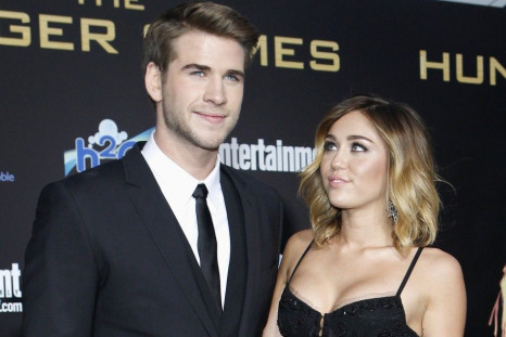 Cast member Liam Hemsworth poses with actress Miley Cyrus at the premiere of &quot;The Hunger Games&quot; at Nokia theatre in Los Angeles
