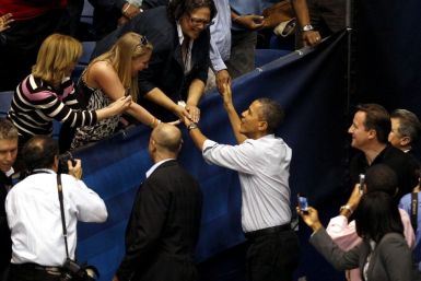 U.S. President Barack Obama greets supporters as he arrives with British PM David Cameron