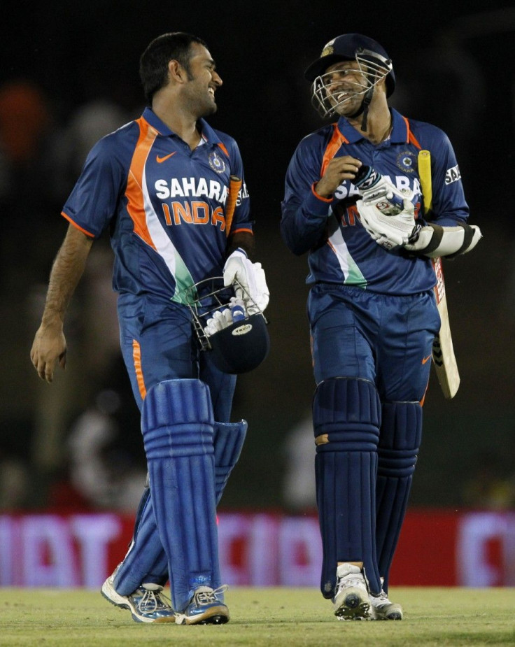 India's Sehwag and captain Dhoni share a laugh as they walk off field after their team's victory.