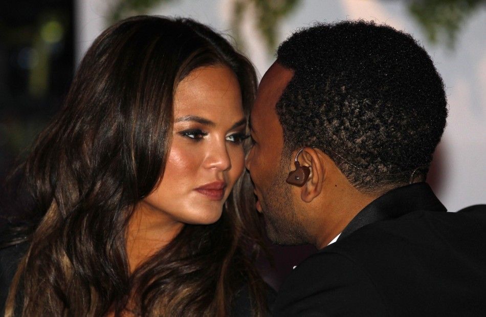 Singer John Legend and his girlfriend Chrissy Teigen kiss at the State Dinner held to honor British Prime Minister David Cameron at the White House in Washington March 14, 2012.