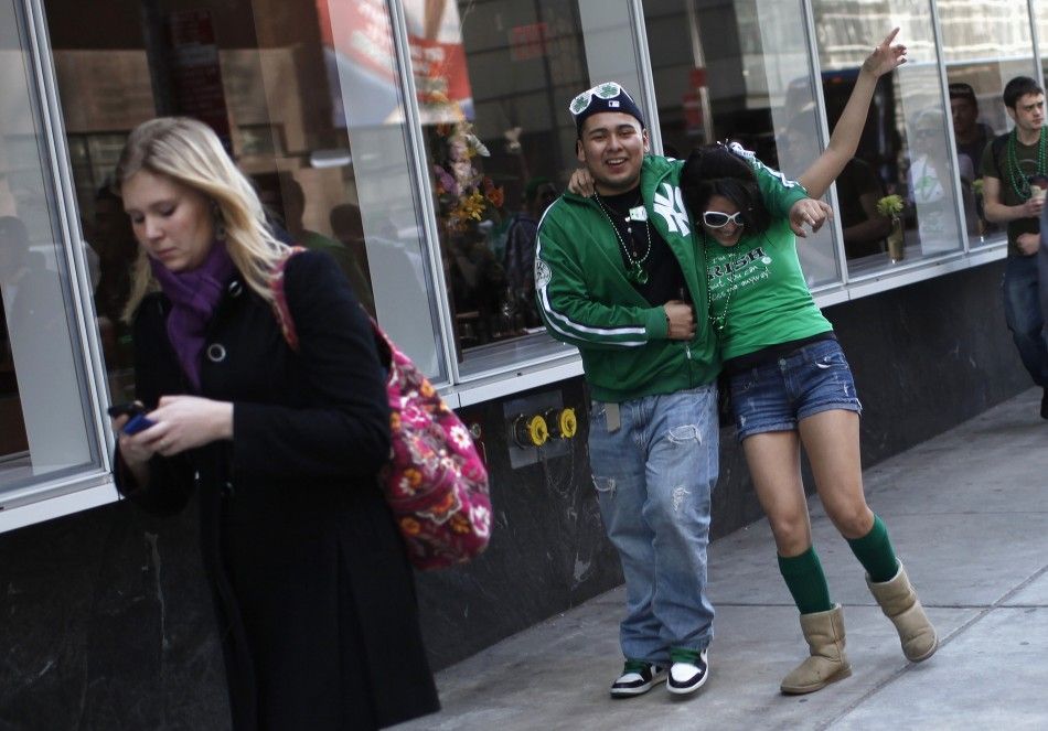 A man helps a woman down the sidewalk as they celebrate along 5th Avenue in New York during the citys 250th annual St. Patricks Day parade, March 17, 2011.