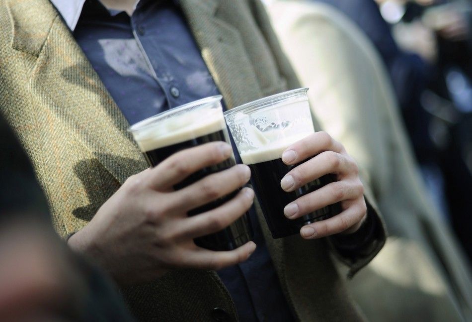 A man drinks two pints of Guinness as he watches the races on Saint Patricks day at the Cheltenham Festival horse racing meet in Gloucestershire, western England March 17, 2011.