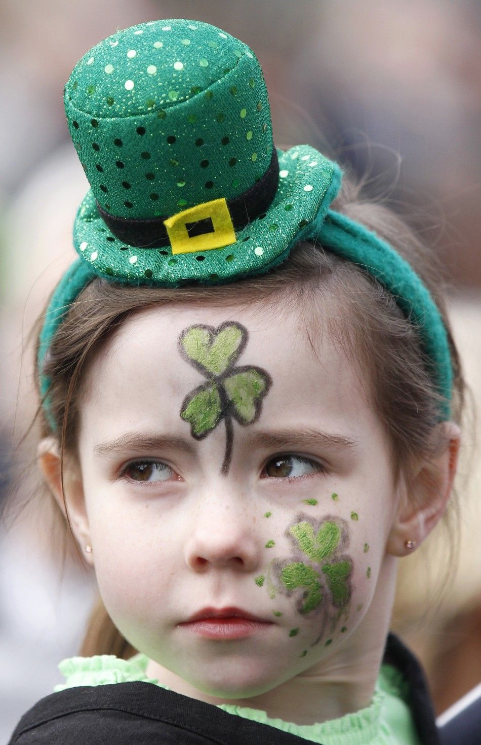 A young girl with her face painted watches the annual St. Patricks Day parade in Belfast, Northern Ireland March 17, 2011. 