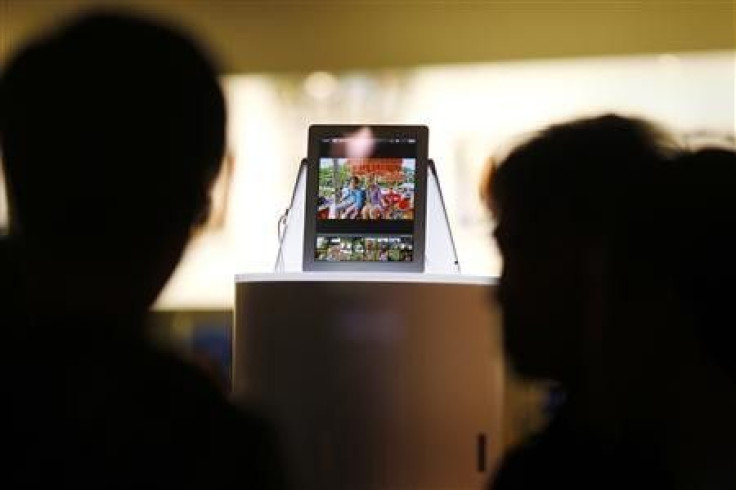 Passers-by look at a new iPad in a window display in an Apple store in Sydney March 15, 2012.