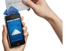 A PayPal Here device affixed to a mobile phone is demonstrated in a handout photo.