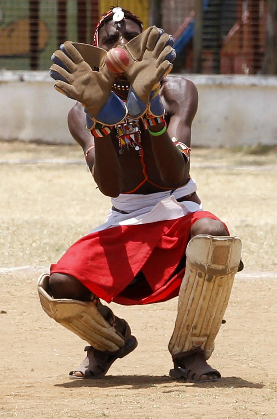 A member of the Maasai Cricket Warriors team catches the ball during their friendly match in Mombasa