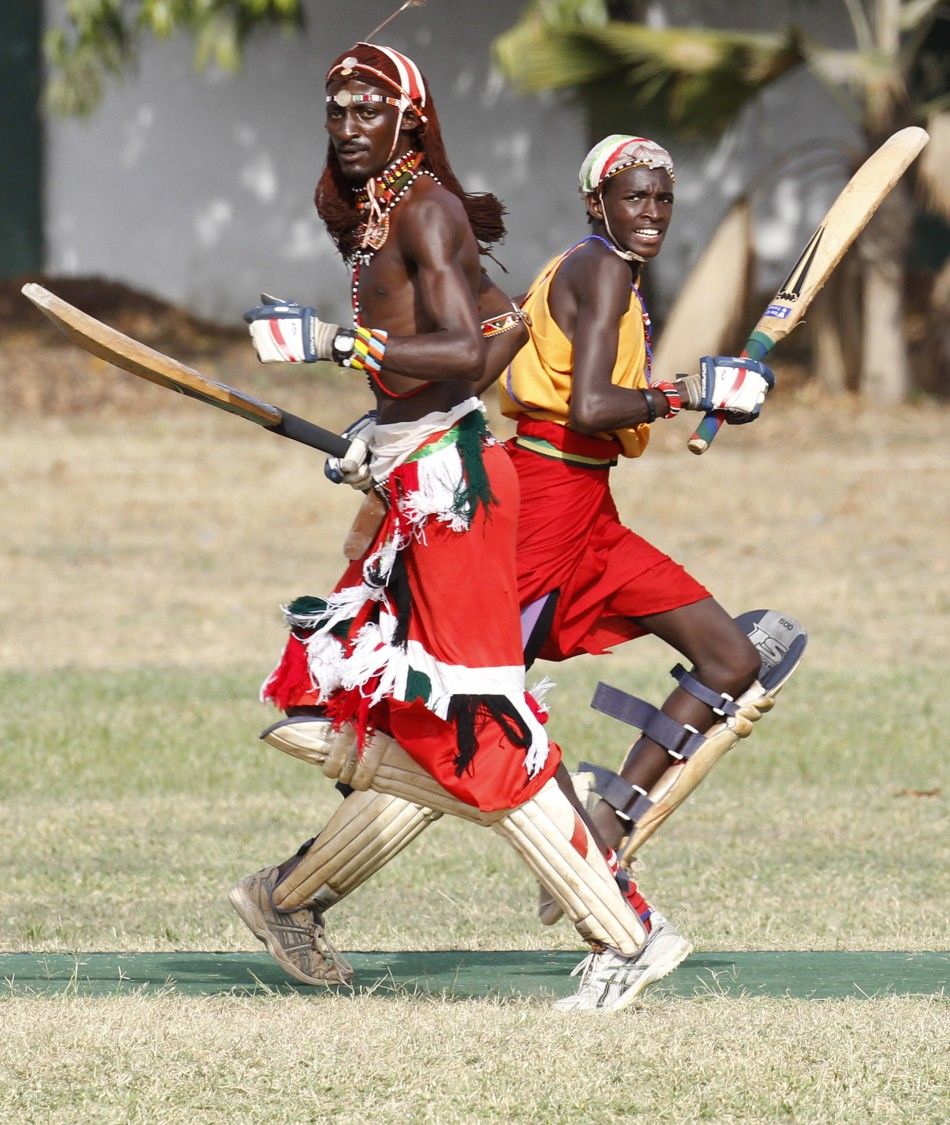 Ole Mamai of the Maasai Cricket Warriors and his teammate Ole Ngais run between the wicket against the Jafferys team during their friendly match in the Kenyan coastal city of Mombasa