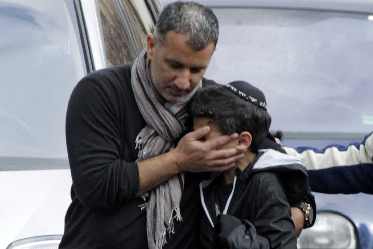 A school student is escorted as he leaves the Ozar Hatorah Jewish school in Toulouse, southwestern France