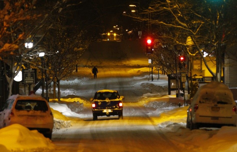 A pedestrian walks along San Francisco Street as several inches of snow cover the ground in Flagstaff, Arizona March,18 2012. The late winter storm kept temperatures well below normal in California on Sunday and generated heavy snow fall in several states