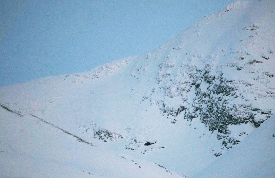 A helicopter searches a mountain area where an avalanche is reported, in Kafjord