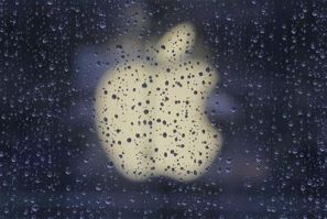 Raindrops are seen in front of an Apple logo outside an Apple store in Shanghai February 22, 2012.