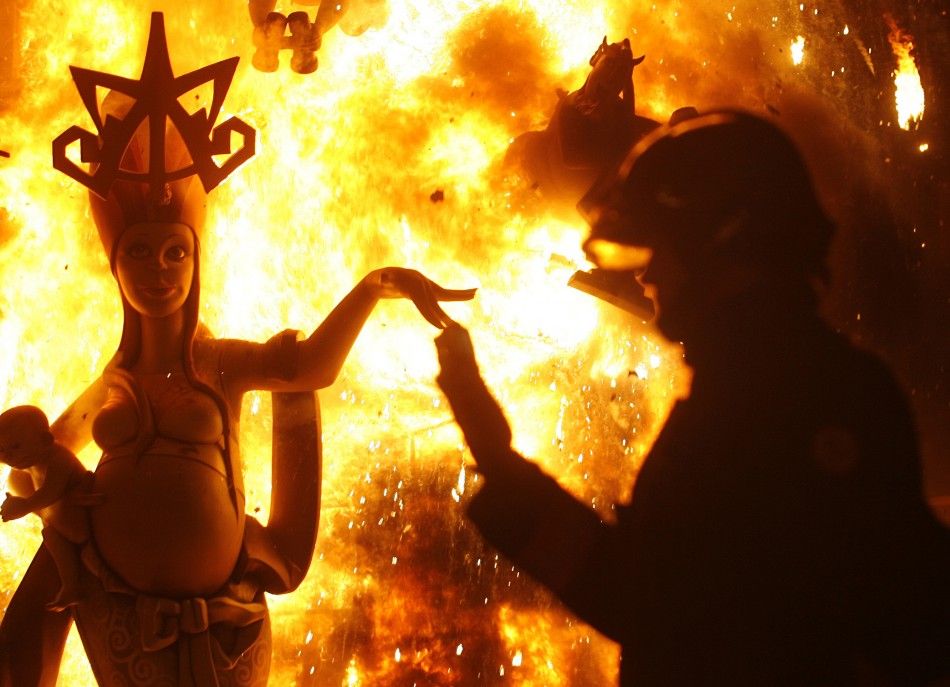 A fireman controls a burning effigy during finale of Fallas festival, which welcomes spring and honours Saint Joseph039s Day, in Valencia