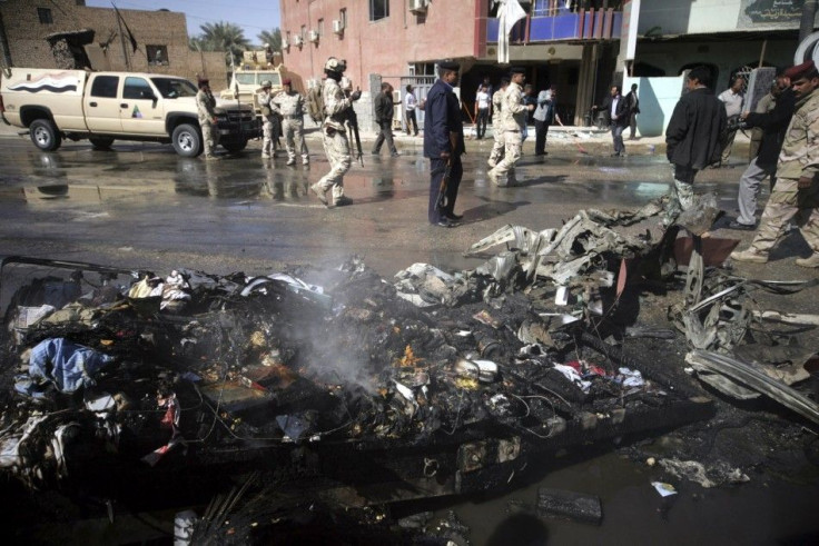 Iraqi security forces inspect the site of a bomb attack in Kerbala