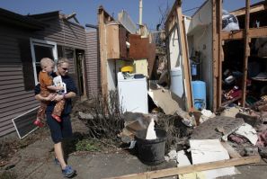 Katie Clifford carries her son as she looks at her home destroyed by a tornado in Dexter, Michigan, March 16, 2012.