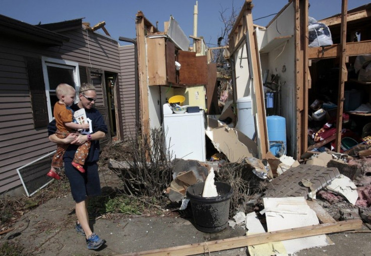 Katie Clifford carries her son as she looks at her home destroyed by a tornado in Dexter, Michigan, March 16, 2012.