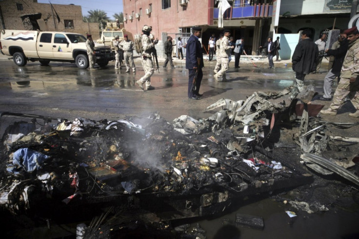 Iraqi security forces inspect the site of a bomb attack in Karbala