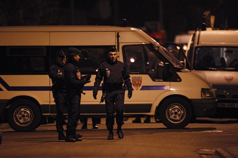 French CRS police block a street during a raid on a house to arrest suspects in the killings of three children and a rabbi on Monday at a Jewish school, in Toulouse