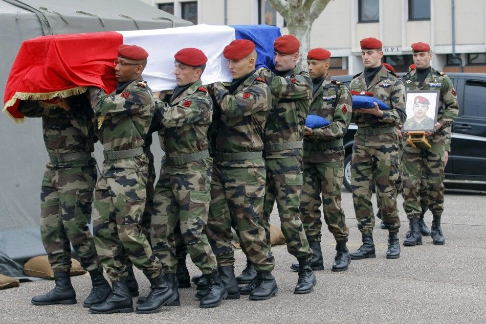 Soldiers carry the coffin of a victim before a ceremony to pay homage to the three soldiers at the 17th RGP paratroopers regiment in Montauban