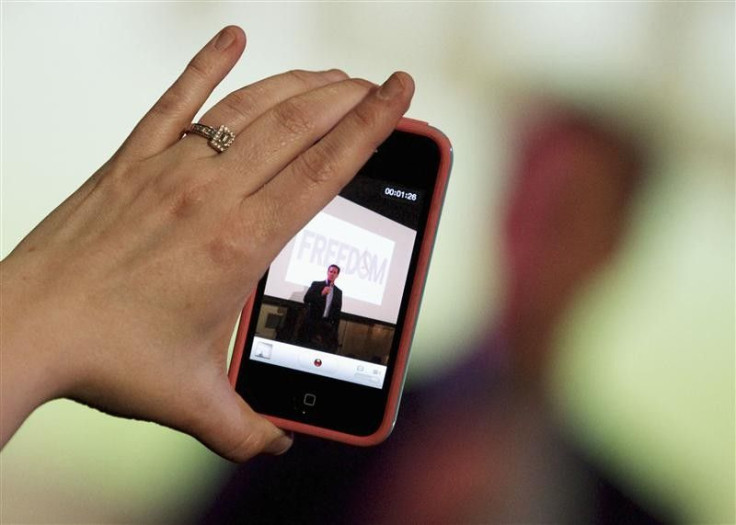 A woman takes a video with her iPhone as Republican presidential candidate and former U.S. Senator Rick Santorum addresses supporters at a Get Out The Vote rally in Mandeville, Louisiana March 21, 2012.