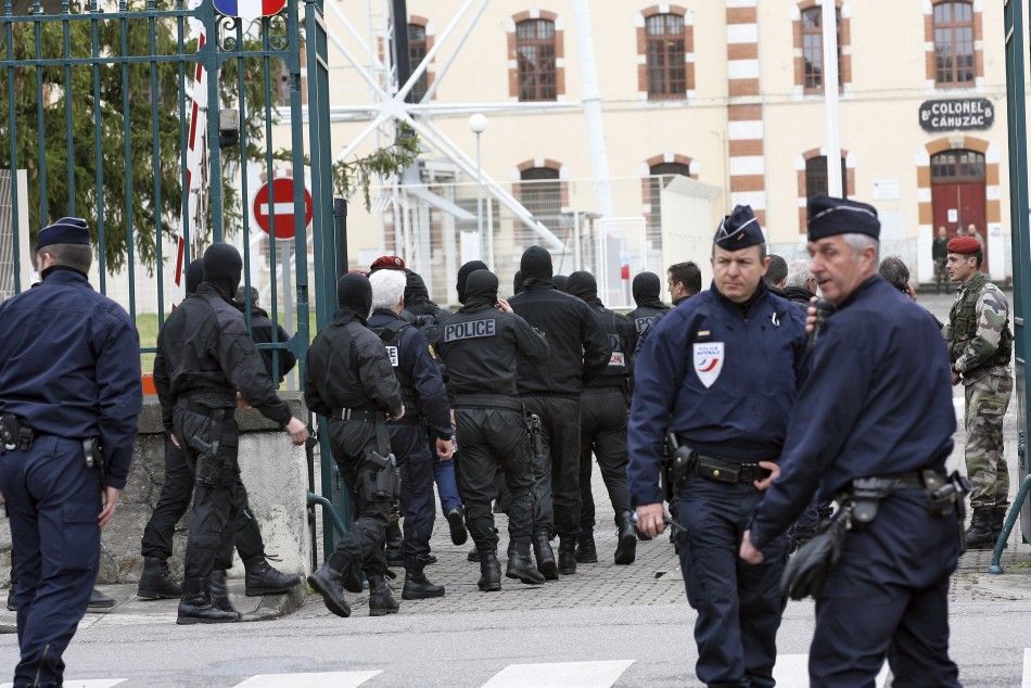 Masked French special unit policemen leave after the assault to capture gunman Mohamed Merah during a raid on a five-storey building in Toulouse