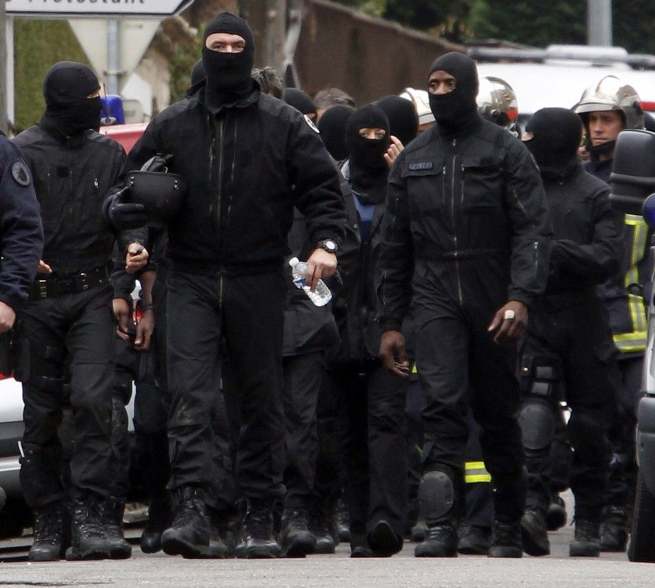 Masked French special unit policemen leave after the assault to capture gunman Mohamed Merah during a raid on a five-storey building in Toulouse
