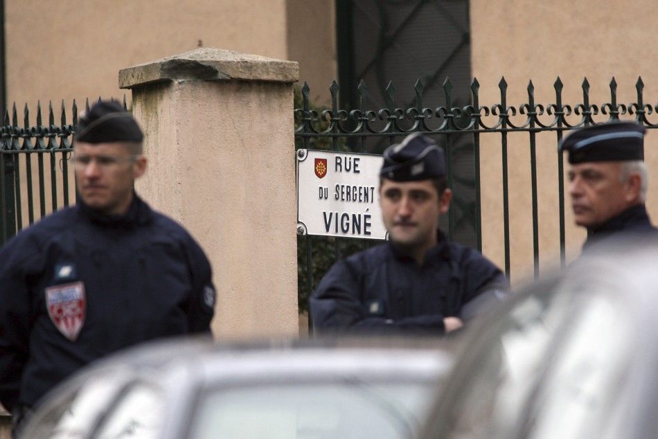 French CRS police secure a street during a raid on a house to arrest suspect in the killings of three children and a rabbi on Monday at a Jewish school, in Toulouse