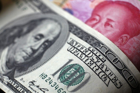 File photo of a Chinese 100 yuan banknote being placed under a $100 banknote in this photo illustration taken in Beijing