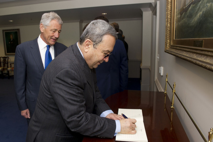 Barak signs the guest book at the Pentagon with Hagel