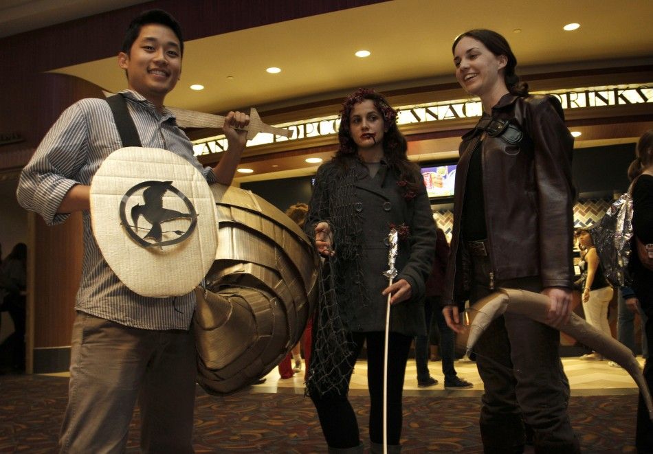 L - RFans Kyle Apuna, Sierra Betinis and Amanda Hearle dressed up as characters from quotThe Hunger Gamesquot pose on the opening night at Regal Cinemas in Los Angeles, California March 22, 2012. 